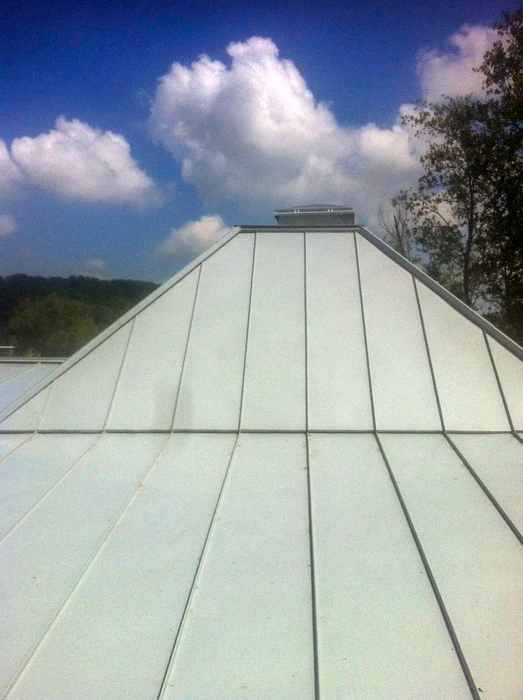 Toiture métallique en zinc ou acier laqué blanc, vue en perspective vers le faîtage pyramidal