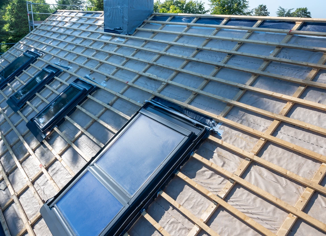 Couvreur professionnel travaillant sur une toiture, installant ou réparant des éléments de couverture