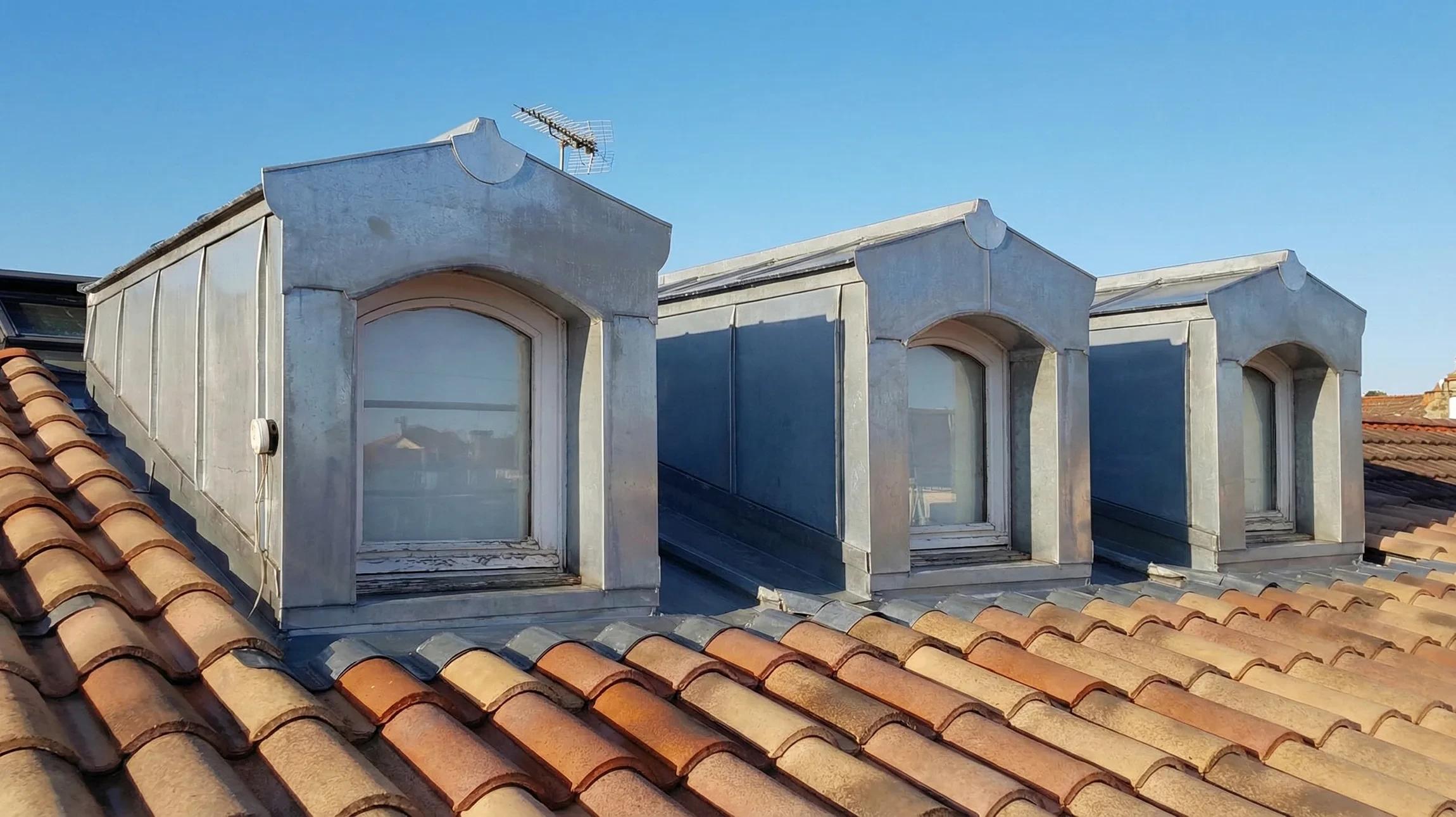 Ext&eacute;rieur d'une maison avec toiture en tuiles canal terre cuite et syst&egrave;me d'&eacute;vacuation des eaux pluviales